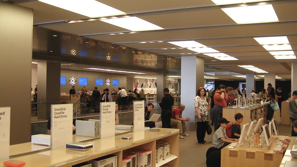 苹果零售店内部,木制展示桌与顾客