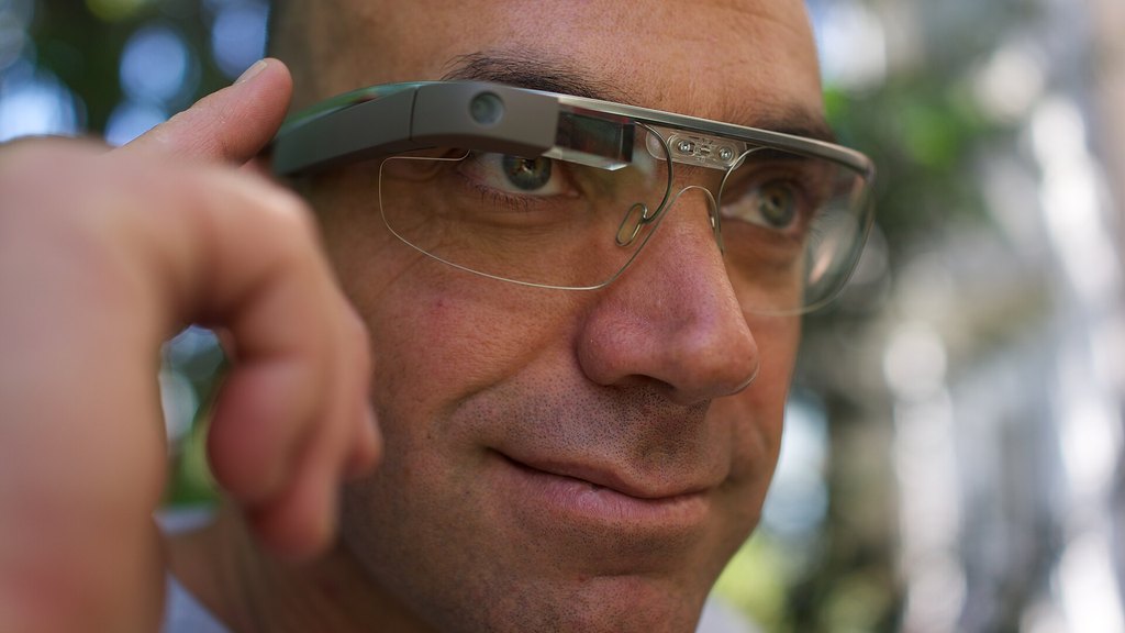 一位男士佩戴智能眼镜（Google Glass 样式）的近景