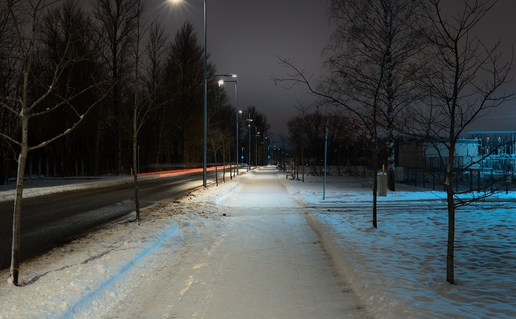 夜晚雪后的城市道路，车灯拉成长长的光带